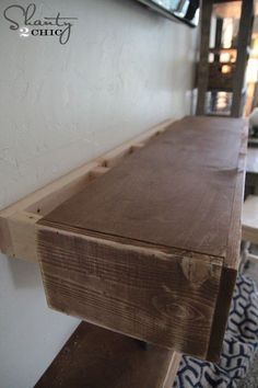 a wooden table sitting on top of a white wall