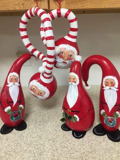 three red and white christmas decorations with santas on them