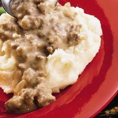 a red plate topped with mashed potatoes and gravy