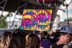 a group of people standing around each other holding signs