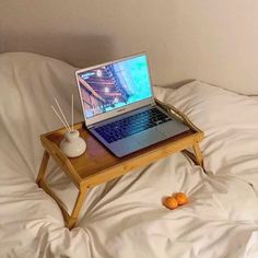 an open laptop computer sitting on top of a wooden tray