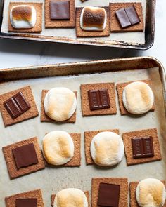 there are many cookies and marshmallows on the baking sheet