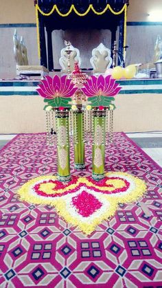 two vases filled with flowers sitting on top of a colorful rug in front of a mirror