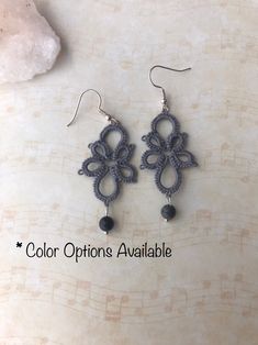 a pair of earrings with black beads hanging from them