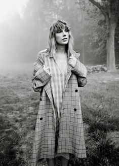 a woman standing in the grass with her hands on her hips