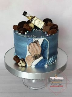 a cake decorated with an image of a man's hand and wine bottle