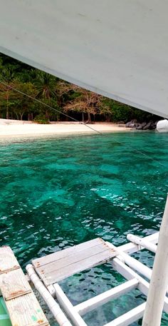 the water is crystal blue and clear as it sits in front of a white boat