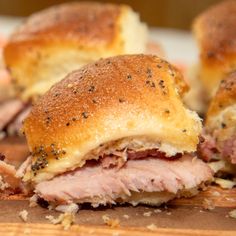 ham and cheese sliders cut in half on a cutting board with other meats