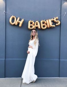 a woman standing in front of a sign that says oh babies