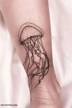 a small jellyfish tattoo on the right arm and leg, with black ink in it