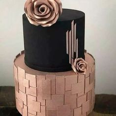 there is a black and pink cake with flowers on it