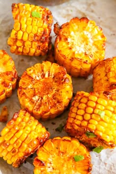 grilled corn on the cob with herbs and seasoning sitting on paper towel