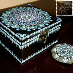 a decorative box sitting on top of a wooden table next to a small round object