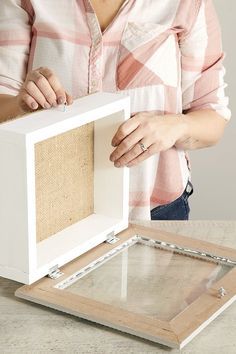 a woman is opening up a box with some burlocks on the bottom and inside