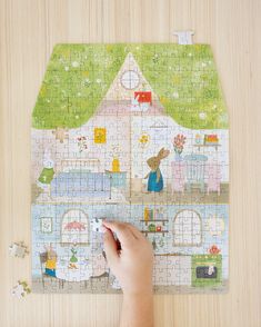 a child's hand is playing with a puzzle