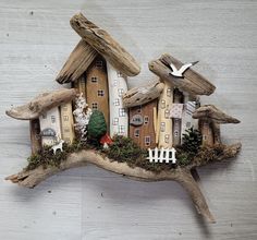 a bird is sitting on top of a piece of driftwood that looks like a house