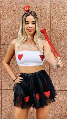 a woman wearing a heart skirt and crop top, holding a baseball bat in her hand