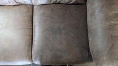 a close up view of the back end of a reclining couch with two pillows on it