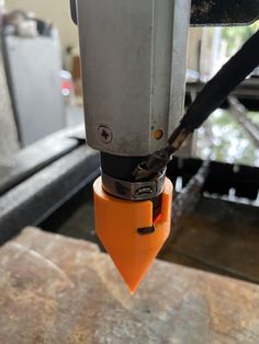 an orange object being worked on in a machine shop