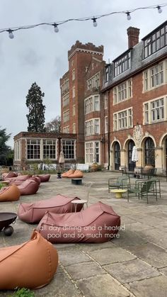 there are many bean bag chairs outside on the ground in front of an old brick building