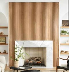 a living room filled with furniture and a fire place in front of a wooden wall