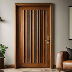 a wooden door in a living room next to a brown chair and potted plant