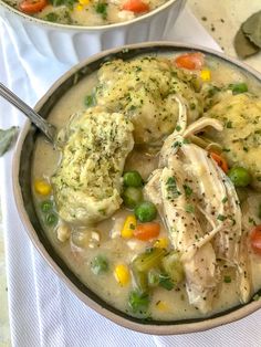 a bowl filled with chicken, dumplings and veggies