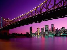 an image of a bridge that is going over the water with buildings in the background