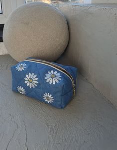 Quilted denim cosmetic bag makes a luxurious addition to any accessory collection. This blue denim toiletry bag with embroidered daisies and a gold zipper it's a perfect piece to bring a touch of elegance to everyday life. Blue Denim Bag With Zipper Pouch, Rectangular Denim Bag With Zipper Pouch, Blue Rectangular Cosmetic Bag With Zipper Pocket, Daisy Makeup, Embroidered Daisies, Quilted Denim, Bag For Travel, Vanity Bag, Gift For Sister