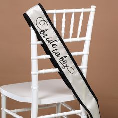 She'll love celebrating her upcoming marriage in fun style with this Bride-To-Be Sash from Hortense B. Hewitt. This satin "Bride-To-Be" sash features an ivory-white design with black grosgrain trim on either side; embroidered black text reads "Bride-To-Be," with a pink heart accent over the "I" completing the fun look. Perfect for bridal showers and bachelorette parties, this white "Bride-To-Be" sash will help the future bride complete any celebratory look with a playful vibe, and she'll love ha Ivory Bride, Embroidered Lettering, Bride To Be Sash, Bachelor Parties, Pre Wedding Party, Engagement Parties, White Bride, Invitation Ideas, Bridal Sash