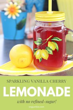 a jar of lemonade sitting on top of a yellow plate next to a lemon