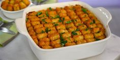 a casserole dish filled with tater tots and garnished with parsley