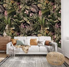 a living room with a white couch and wallpaper that has tropical leaves on it