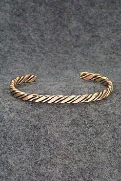 This copper, nickel and brass bracelet was made by Navajo silversmith Verna Tahe. Size: 5 1/8" (will fit up to a 6 1/8" wrist) Gap: 1" Width: 1/4" Free shipping on all orders! We ship with USPS and always include tracking. All orders ship within a day of payment. Returns are accepted up to 30 days after you receive your order. Just send us a message. Our shop offers cash back or store credit. The item must be returned in new condition. Antique Finish Adjustable Cuff Bracelet, Unique Adjustable Bracelet With Antique Finish, Adjustable Bracelet With Antique Finish, Unique Adjustable Bracelets With Antique Finish, Bohemian Adjustable Cuff Bracelet With Antique Finish, Adjustable Bohemian Cuff Bracelet With Antique Finish, Adjustable Bohemian Bracelet With Antique Finish, Adjustable Antique Finish Jewelry Bracelet, Adjustable Hand Forged Bronze Bracelets