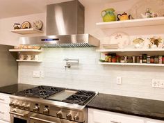 a stove top oven sitting inside of a kitchen next to white cupboards and shelves