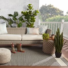 an outdoor patio with potted plants and wicker furniture on the decking area