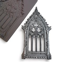 an intricately designed metal object next to a rubber stamp with a design on it