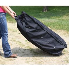 a person pulling a large black bag on the ground with it's handles down