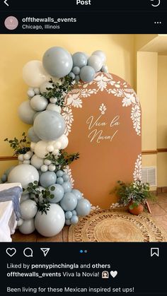 an arch decorated with balloons and greenery for a wedding