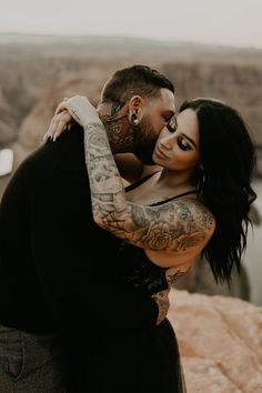 a tattooed man and woman embracing each other