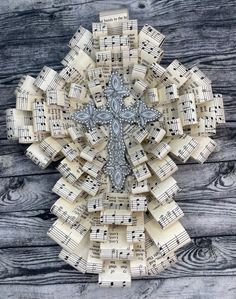 a cross made out of sheet music on top of a wooden table with musical notes