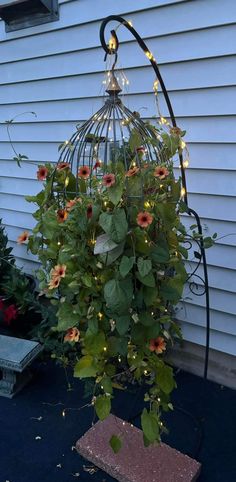 a birdcage filled with flowers and fairy lights