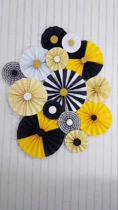 an arrangement of black, yellow and white paper fans