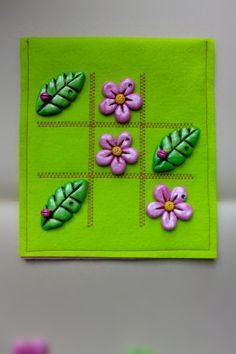 a close up of a green cloth with flowers and leaves painted on it's side