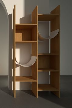 a wooden shelf with plates on it in an empty room next to a white wall