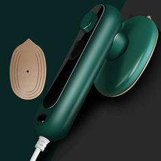 an electric hair dryer sitting on top of a black surface next to a green wall