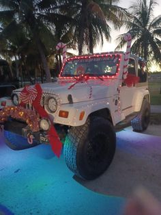 a white jeep decorated with christmas lights and decorations