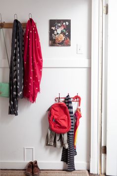 there is a coat rack with clothes hanging on it and shoes in the foreground