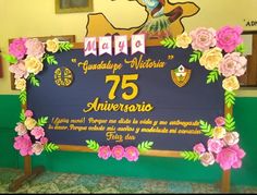 the sign is decorated with paper flowers and leaves for an anniversary celebration or special event