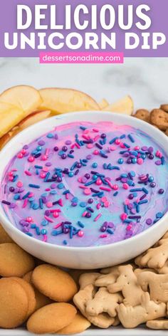 delicious unicorn dip with sprinkles in a white bowl surrounded by cookies and pretzels